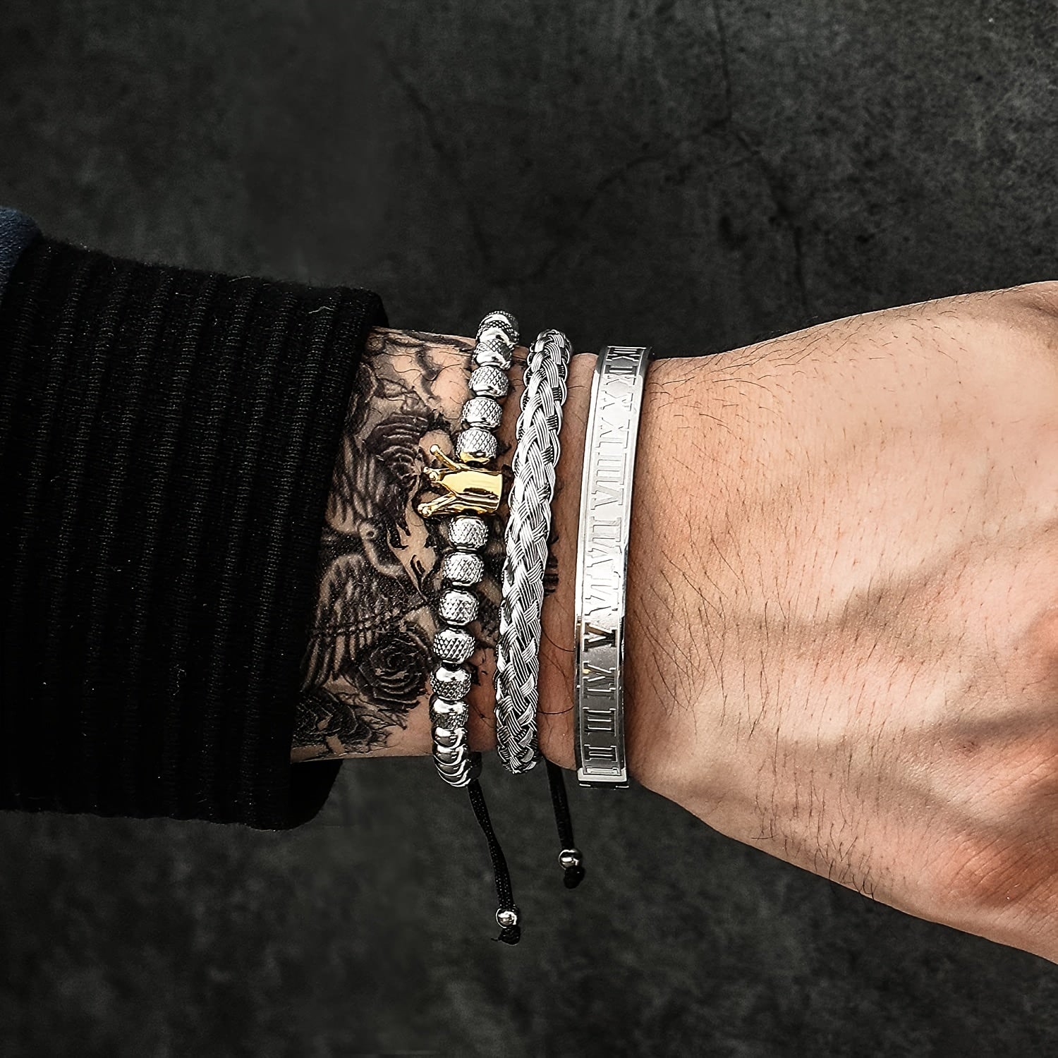 Conjunto de três peças com um estilo luxuoso e discreto: pulseira e bracelete em aço inoxidável polido com trança romana em formato de coroa, um modelo moderno e elegante.